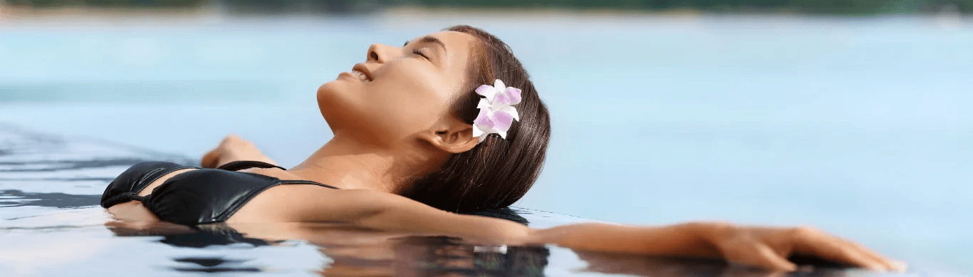 Woman relaxing in water with a flower in her hair
